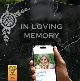 Headstone reading In Loving Memory with a phone held up showing a memorial page