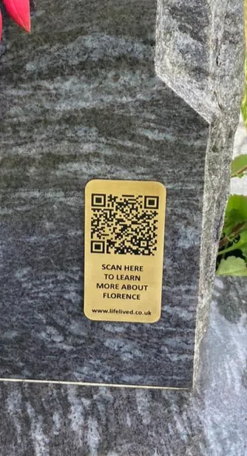 Brass grave memorial plaque with a QR code fixed to a granite headstone
