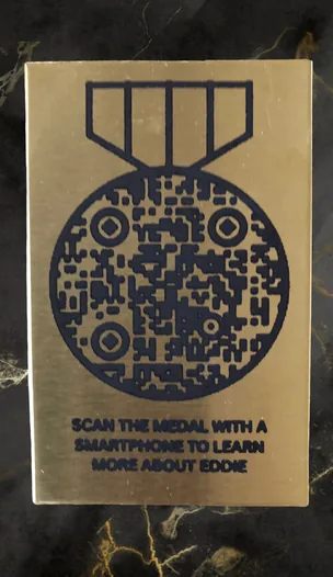 Brass plaque for a headstone with a medal-shaped QR code