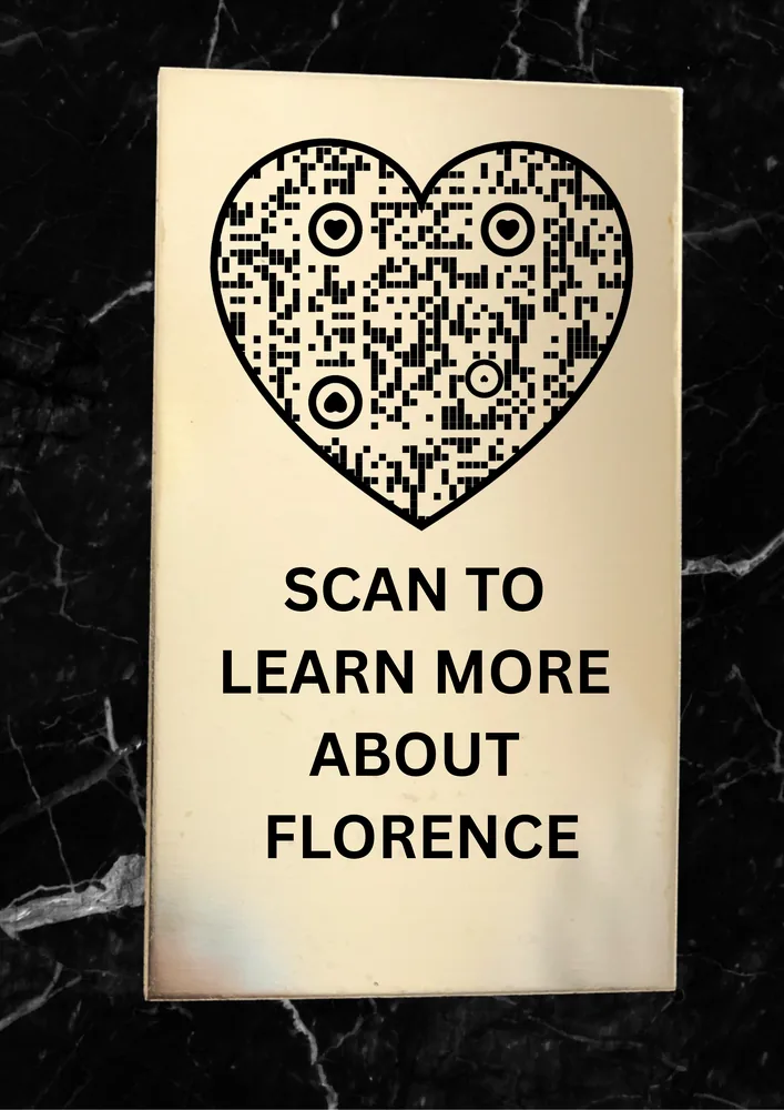 Black memorial plaque with a heart-shaped QR code reading Scan to learn more about Florence