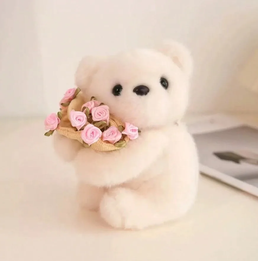 Small cream teddy bear holding a bouquet of pink roses